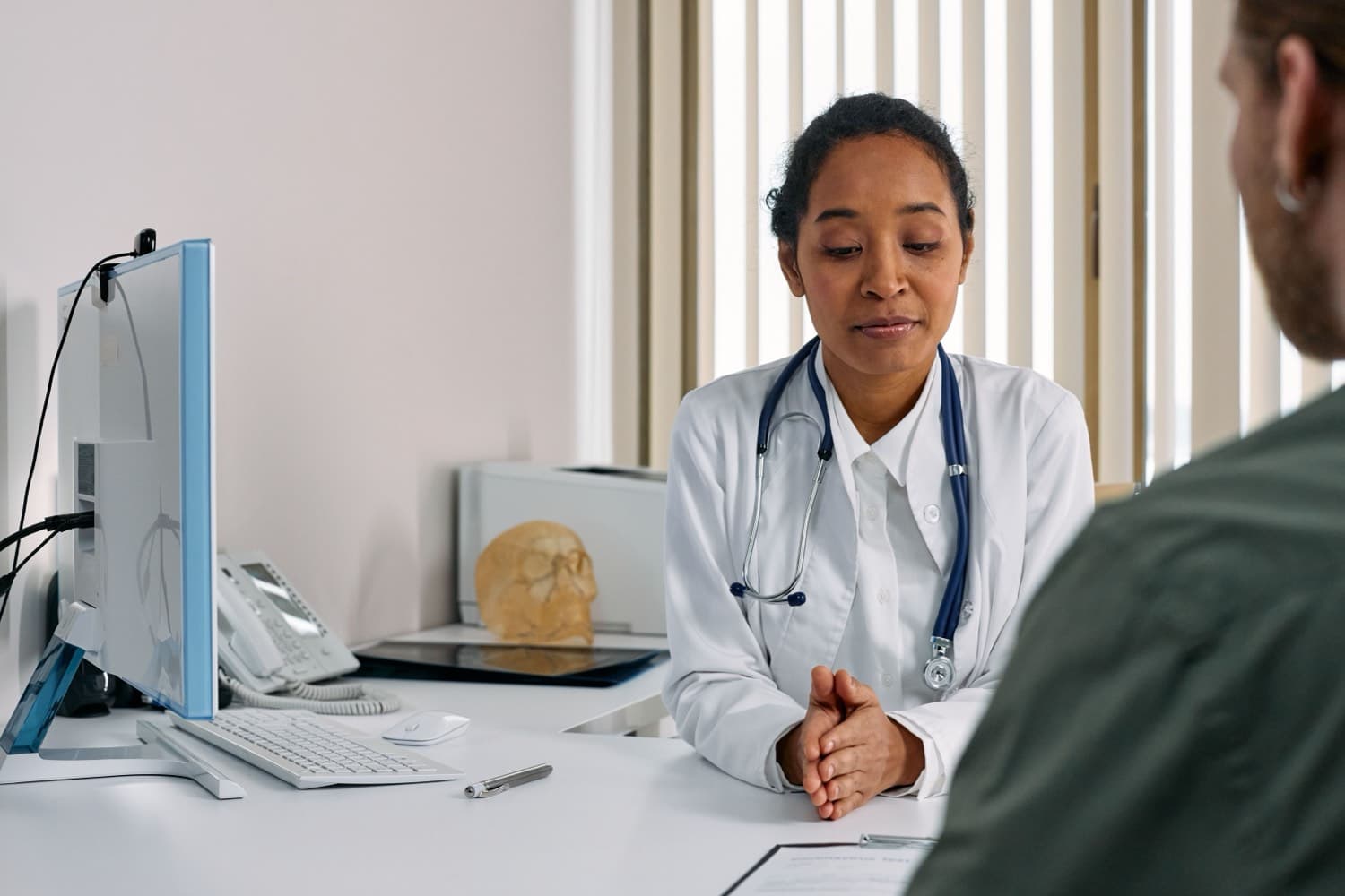 A doctor talking with a patient at a desk