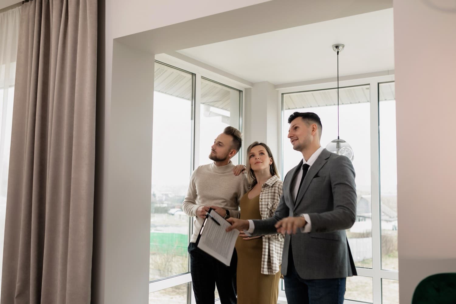 An agent showing a couple a bright new home